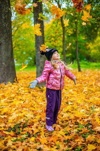 Full length of girl with autumn leaves