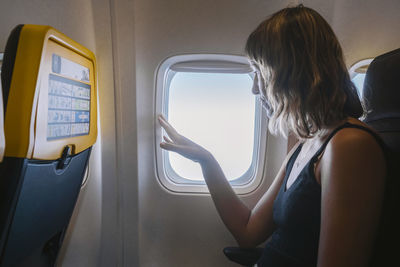 Woman looking through airplane window