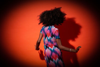 Midsection of woman standing against red background