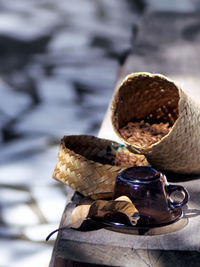 High angle view of coffee beans in basket by cup and leaf on table
