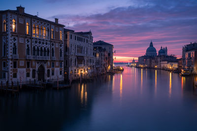 Reflection of buildings in city at sunset