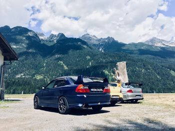 Vintage car on field against mountains