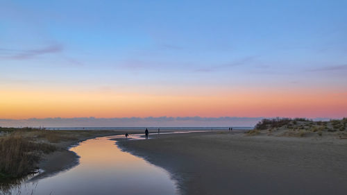 Scenic view of beach against sky during sunset