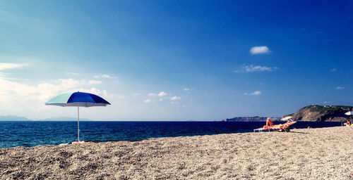 Scenic view of beach against blue sky