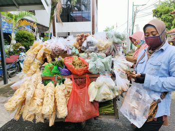 Midsection of woman standing at market stall