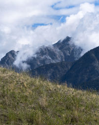 Scenic view of field and mountains against sky