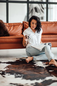 Woman reading magazine while having coffee at home