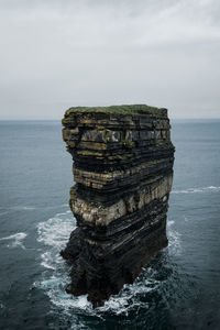 View of rock formation in sea against sky