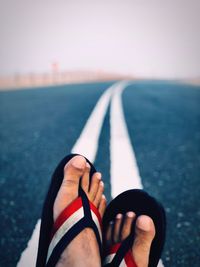 Low section of man relaxing on road