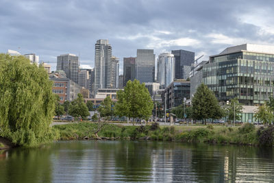 River by buildings in city against sky