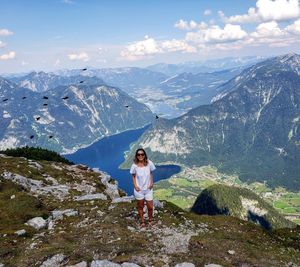 Woman standing on mountain against sky