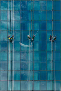Full frame shot of workers on windows against building