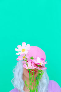 Laughing of woman with pink flowers against colored background