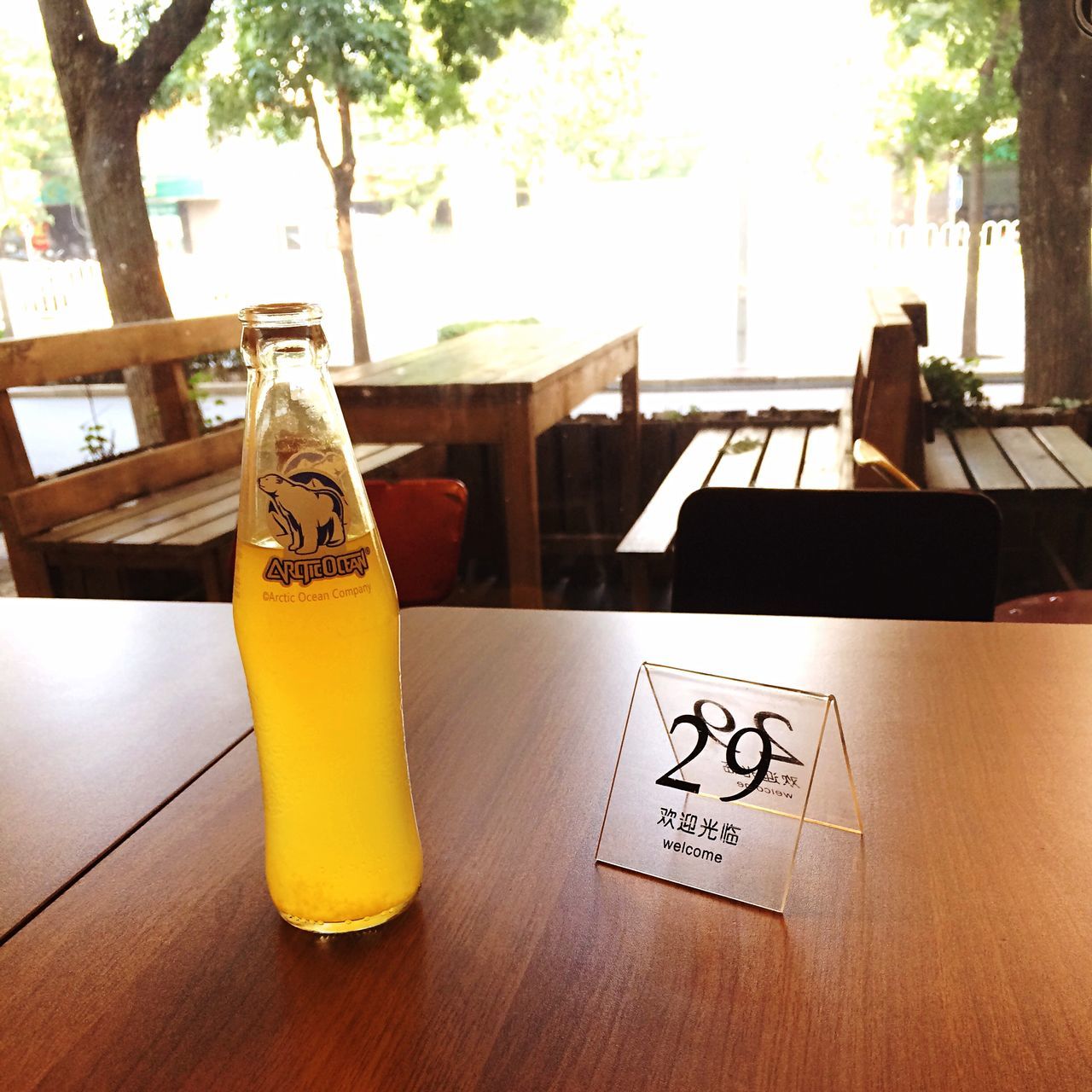 table, indoors, drink, text, still life, food and drink, wood - material, western script, refreshment, no people, absence, shadow, drinking glass, chair, glass - material, close-up, sunlight, empty, day, communication