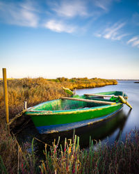 Green boat ashore with salicornia, salt lake near cagliari, sardinia