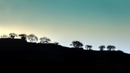 Low angle view of silhouette trees against clear sky