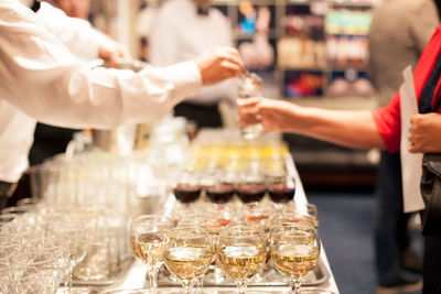 Midsection of bartender giving drink to woman in bar