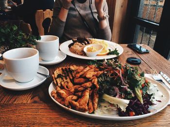 Midsection of woman with meal served on table at restaurant