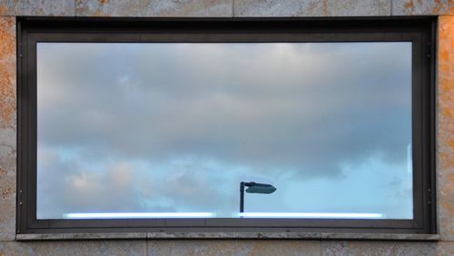 Low angle view of glass window against sky