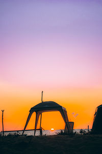 Silhouette beach against sky during sunset
