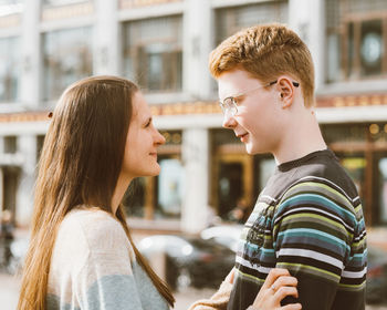 Young couple embracing while standing outdoors