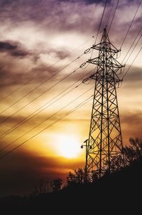 Silhouette electricity pylon against sky during sunset