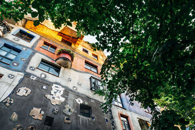 Low angle view of trees and buildings against sky