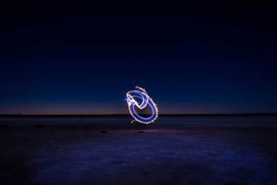 Light painting on beach against sky at night