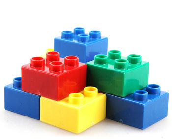 Stack of multi colored toy blocks on white background