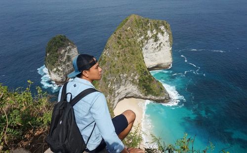 High angle view of man on rock by sea