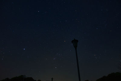 Low angle view of silhouette street light against sky at night