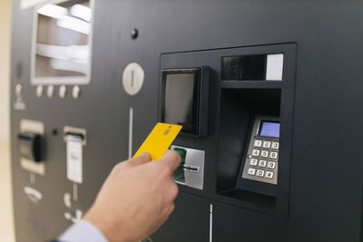 Businessman holding credit card at atm machine