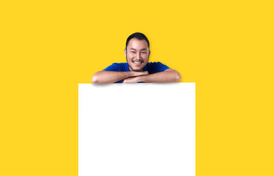 Portrait of a young man against yellow background