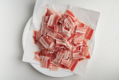 High angle view of chopped bread on table against white background