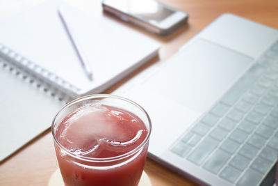 High angle view of drink by laptop on table