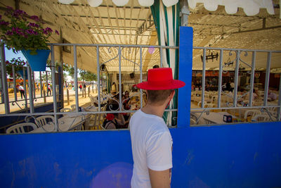 Rear view of boy standing against built structure