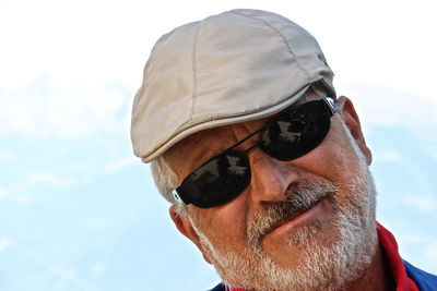 Close-up portrait of man wearing sunglasses against sky