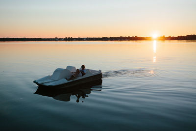 Lake jamno, poland - boy on pedal boat coming in from lake at sunset