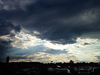 Parking lot against cloudy sky at sunset