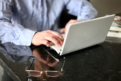 Midsection of man using mobile phone