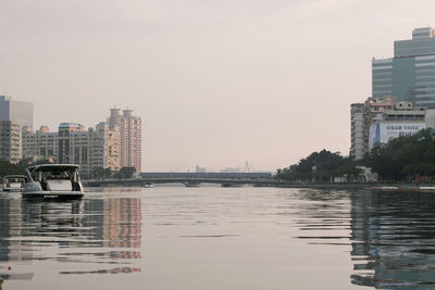 View of river and buildings against clear sky