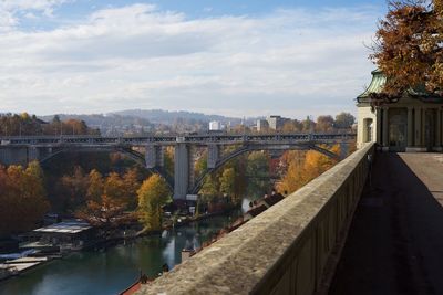 Bridge over river in city against sky