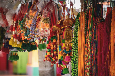 Multi colored decoration and floral garlands hanging for sale in market