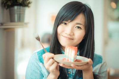 Portrait of smiling woman holding ice cream