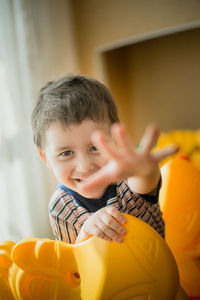 Portrait of boy holding baby at home