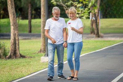 Rear view of people walking on grassland