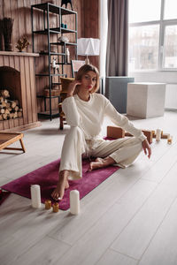 Full length of woman sitting on floor at home