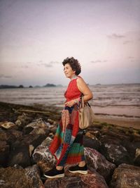 Women strolling on the rocks by the sea in the evening