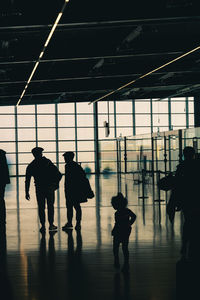 Silhouette people walking on railroad station platform