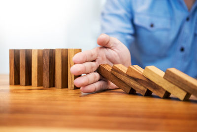 Close-up of man with wooden dominos on table
